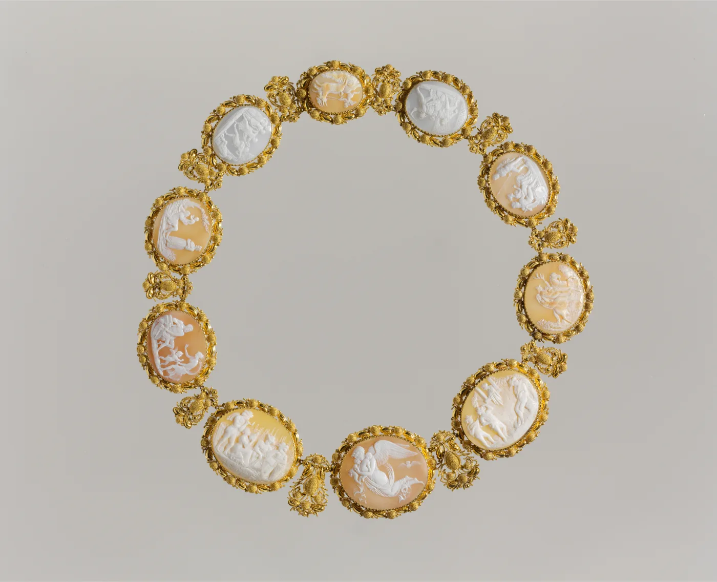 Necklace of eleven shell cameos, each in its own scrolled gold mount, linked into a continuous band