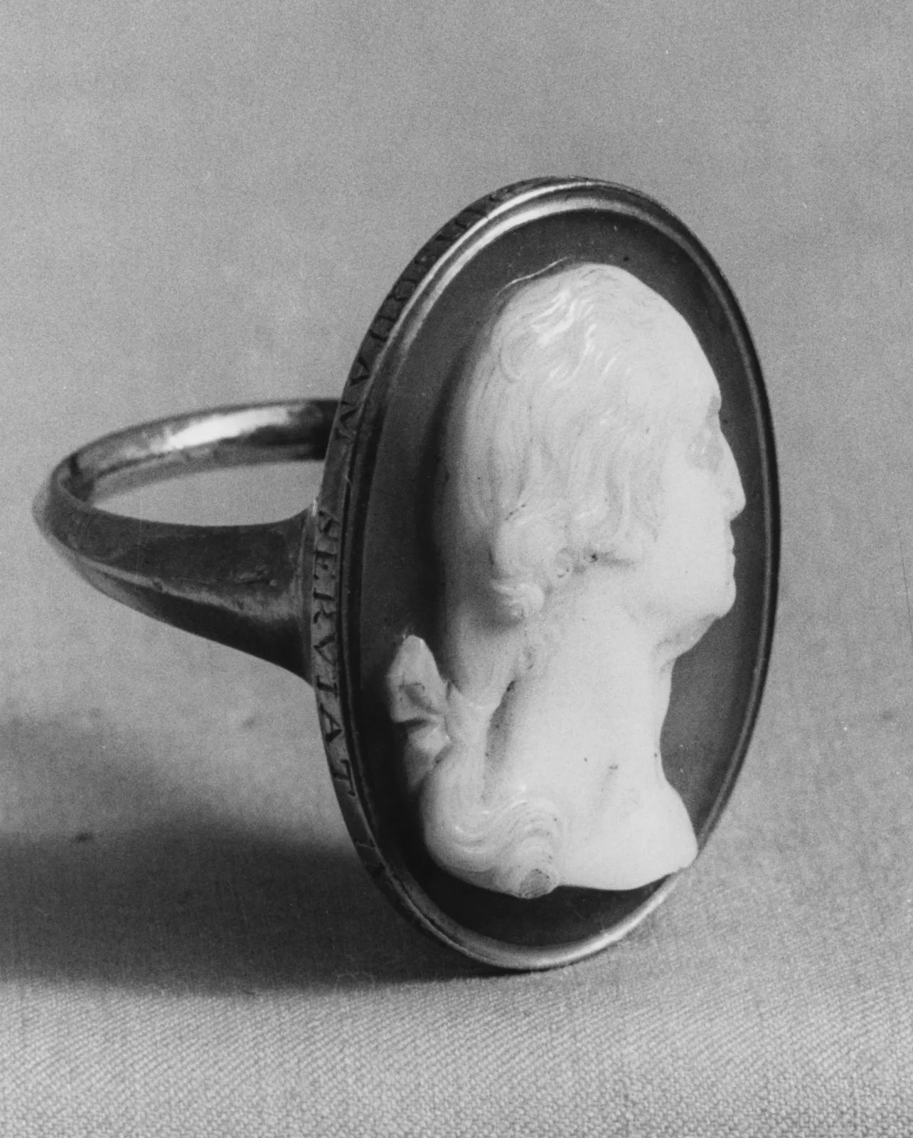 Gold ring set with an onyx cameo carved with a profile head in white against a black ground