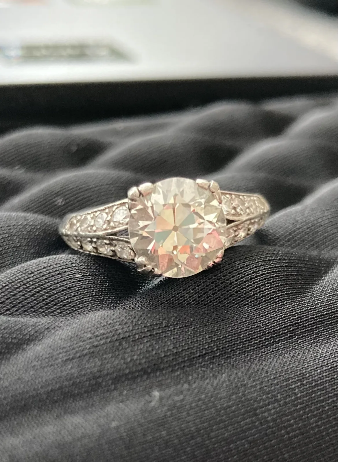 Art Deco style white metal ring set with an old European cut diamond, the shoulders stepped and set with small accent stones