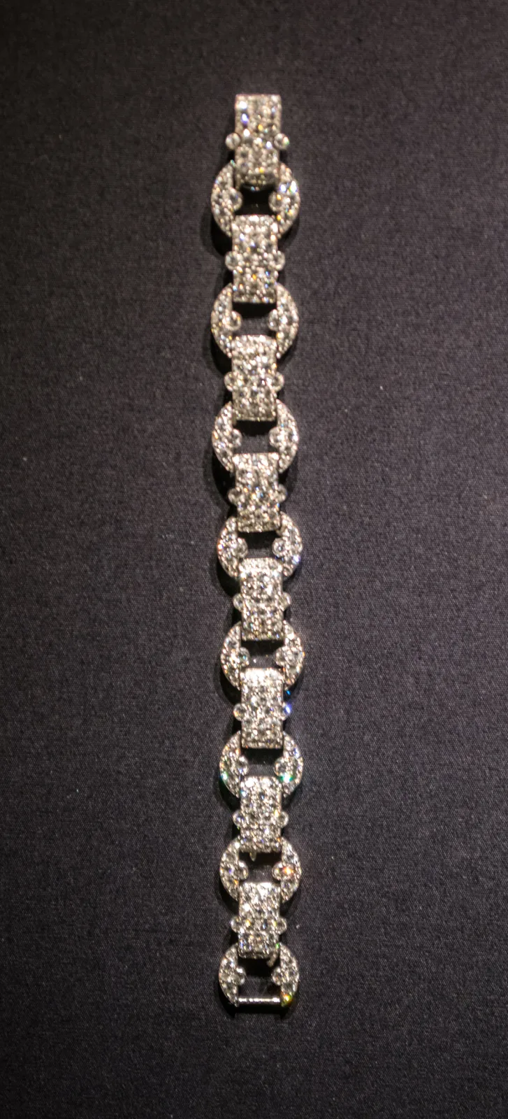 Van Cleef and Arpels loop bracelet formed of repeating diamond-set links, photographed against a dark background