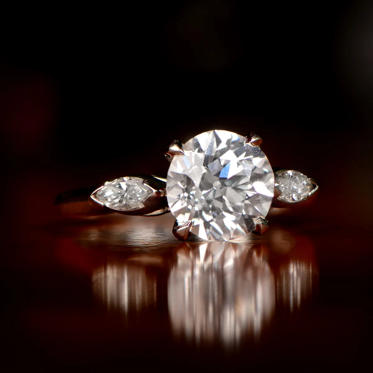 Vintage solitaire engagement ring, the central stone flanked by tapered baguette side stones in a white metal setting