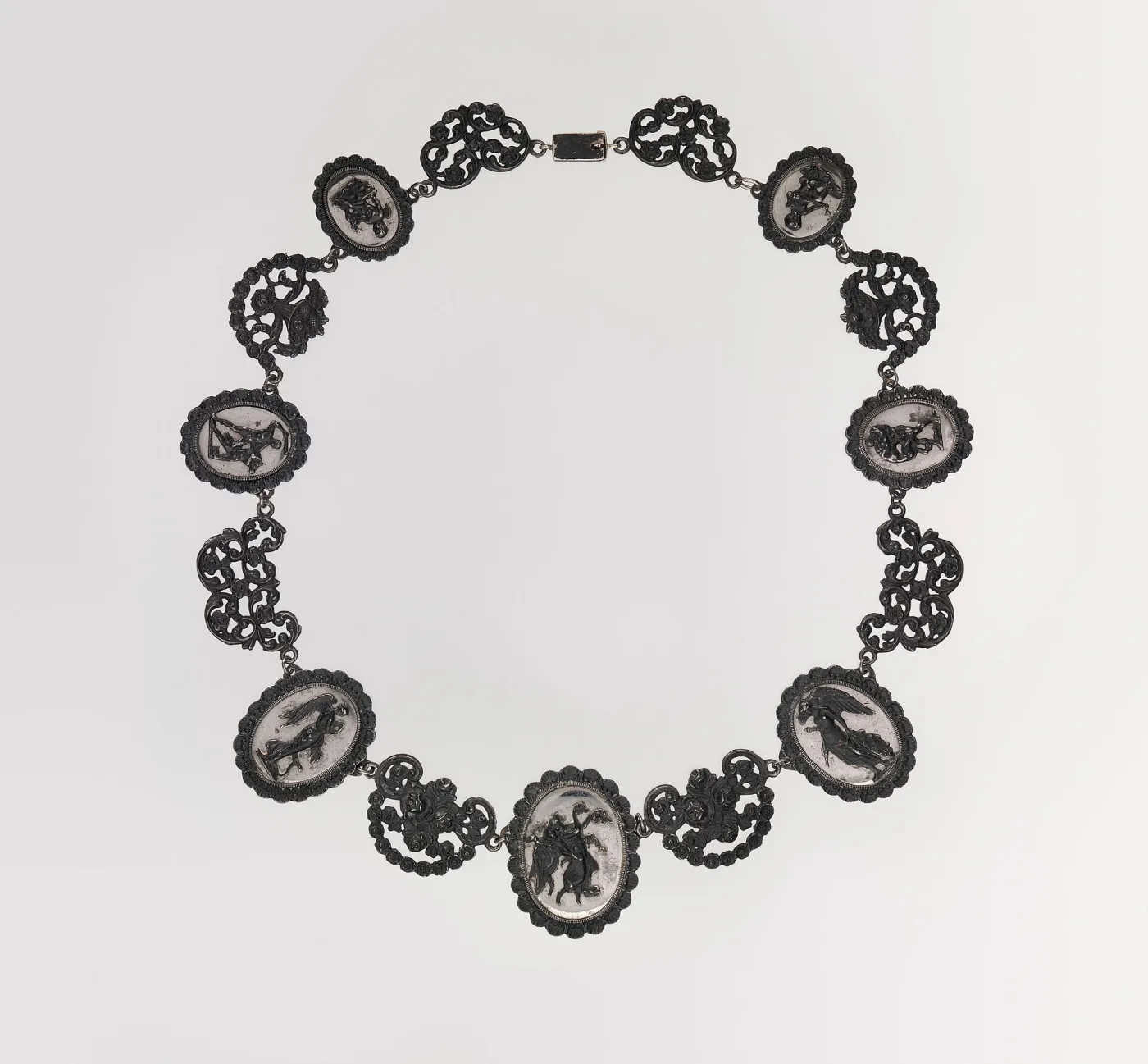 Berlin iron necklace of oval medallions cast with classical figures in relief against a pale ground, alternating with pierced scrollwork links and closed by a plain rectangular box clasp