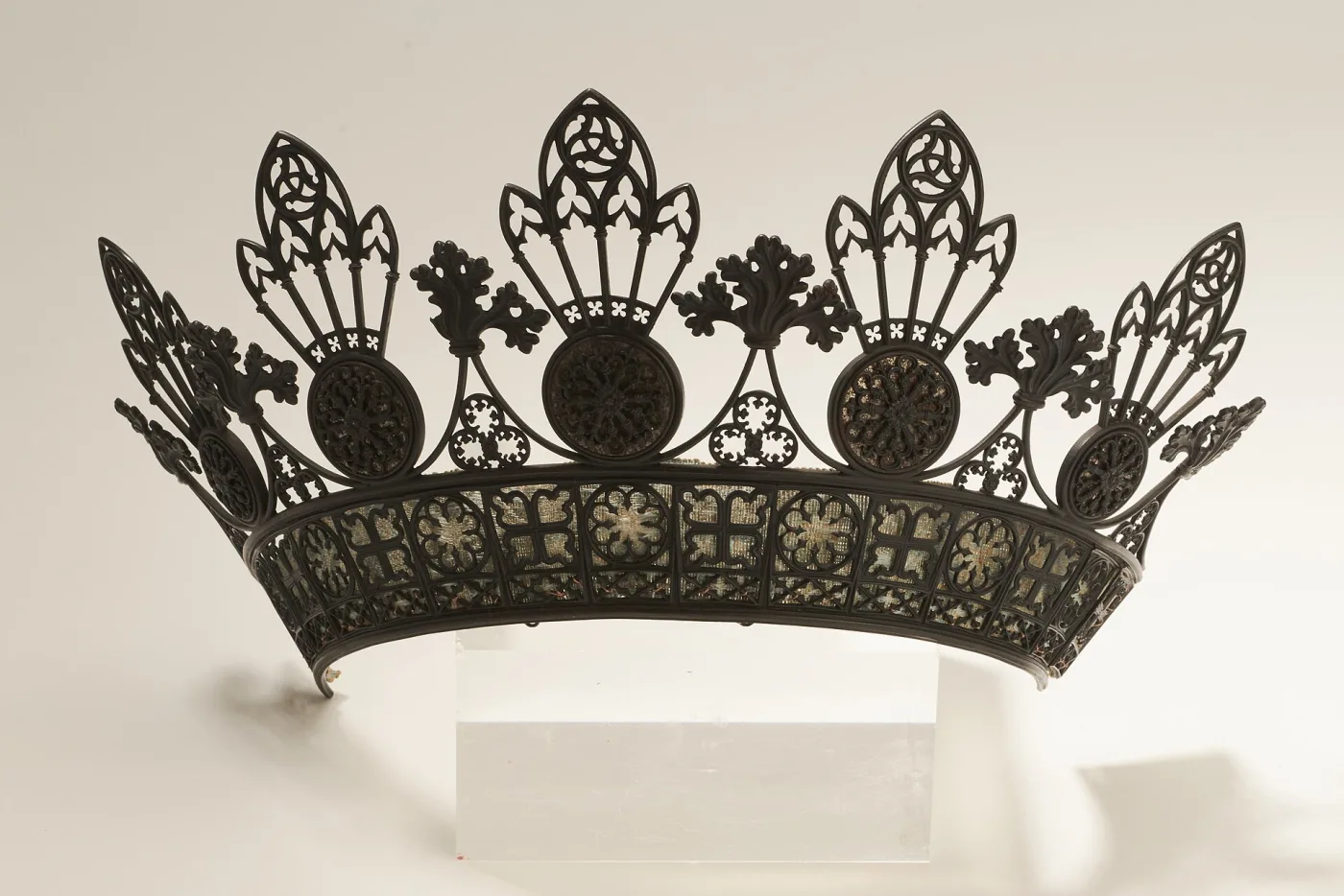 Cast iron tiara with a curved band of Gothic tracery panels supporting five pierced roundels topped by pointed-arch finials, with sprays of oak leaves rising between them