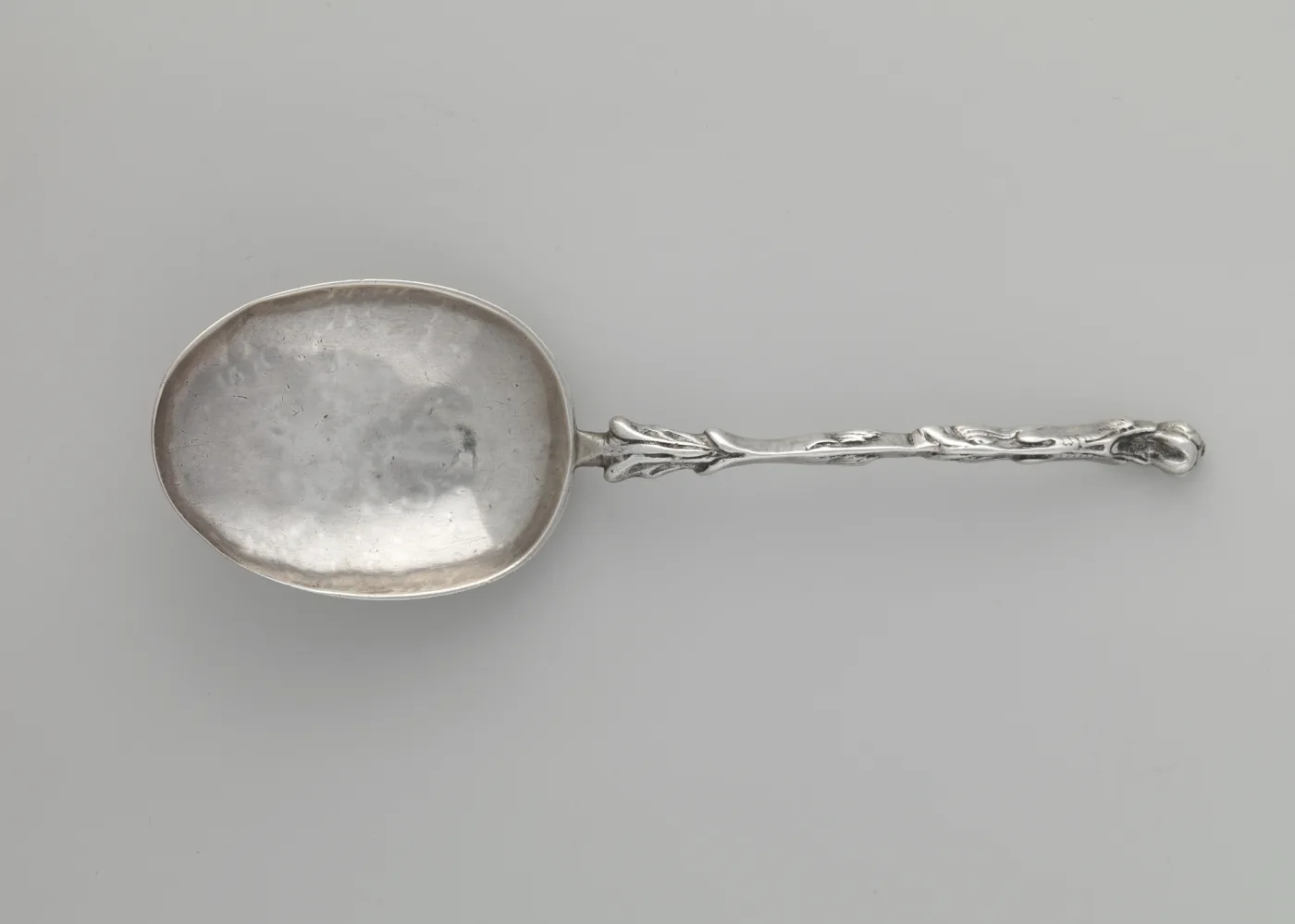Late seventeenth-century silver spoon with a rounded bowl and a slender tapering handle, the surface worn smooth from use