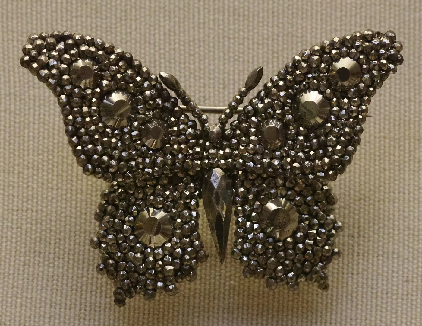 Butterfly-shaped hairpin ornament massed with small faceted steel studs, with larger rosette-cut studs marking the wing spots