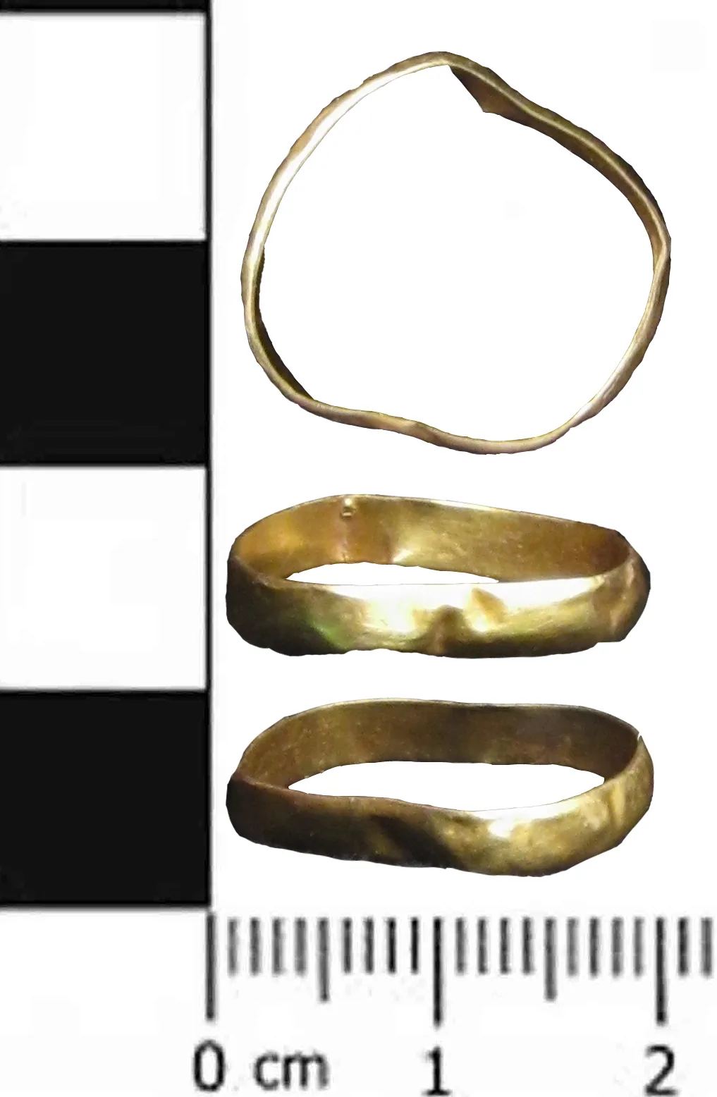 Three views of a thin distorted gold band beside a black and white scale bar, the metal bent out of round