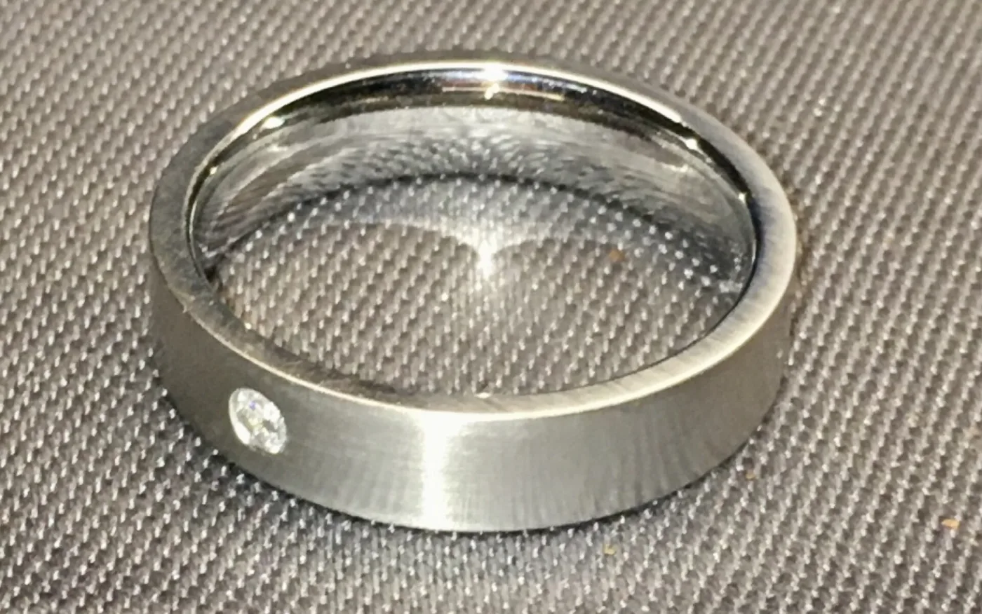 Platinum ring set with a single diamond, the band showing the cool grey-white tone of unplated platinum