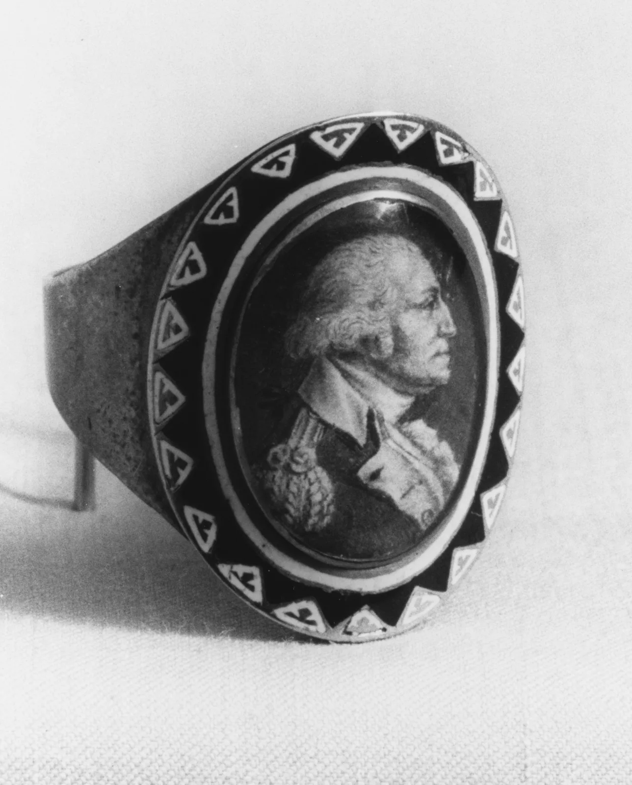 Gold mourning ring with a black enamelled band and a painted portrait bust set under crystal in the oval bezel